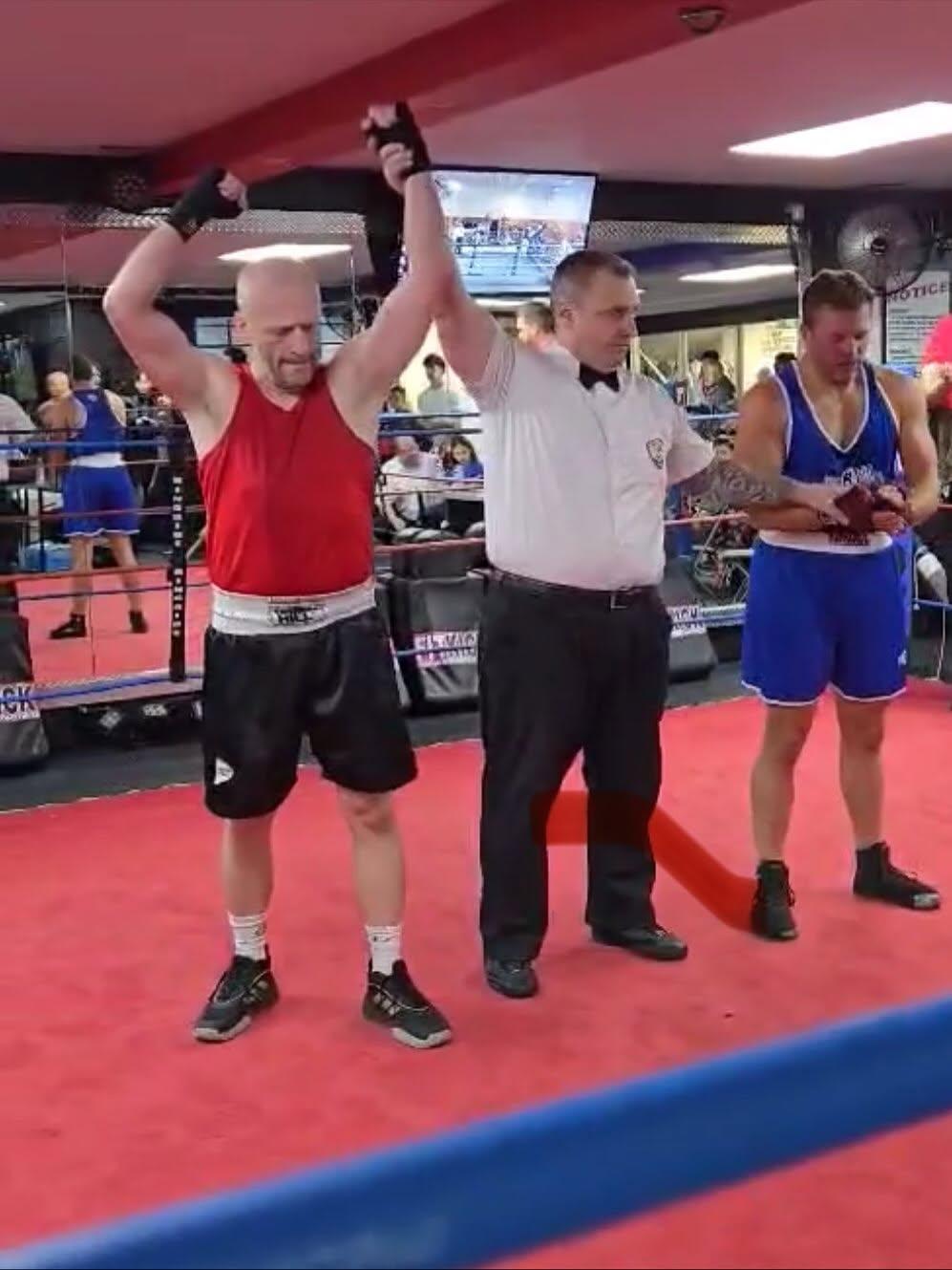 A referee raising a boxer’s hand after a bout