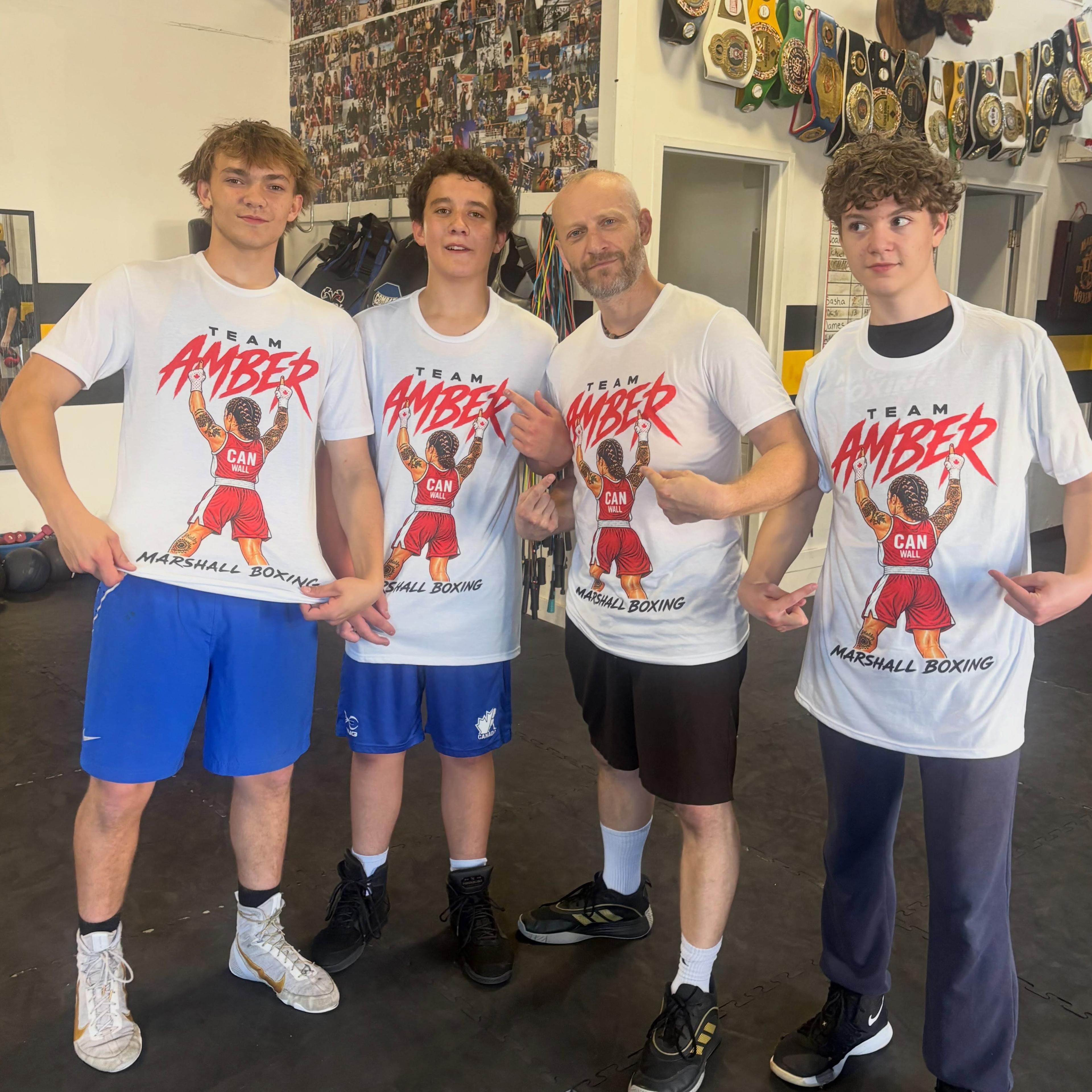 Four club members together at the gym wearing Team Amber shirts