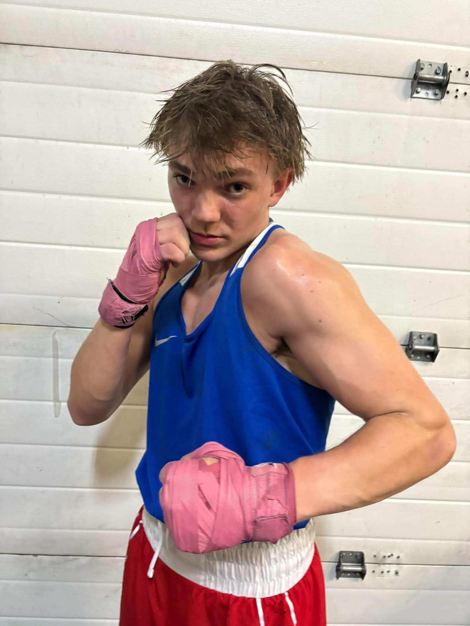 Adrian Davie in a boxing stance wearing blue kit and pink hand wraps