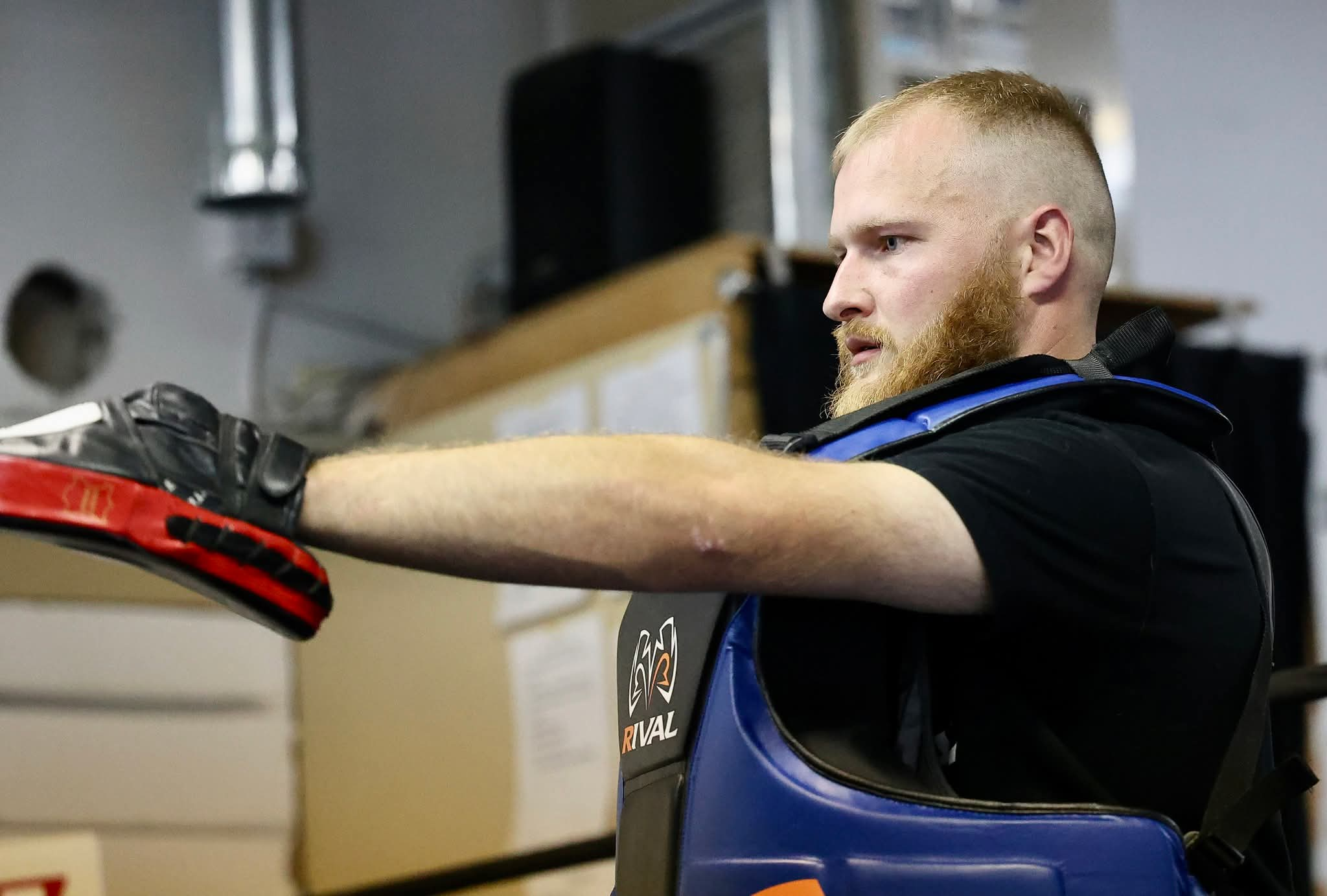 Jacob Roy coaching with focus mitts and a body protector